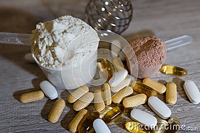 Scoop with whey protein and scoop with chocolate protein and tablets and vitamins omega 3 for sports and dietary nutrition. Stock Photo