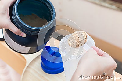 Scoop of whey protein on a wooden plate with jar. Stock Photo