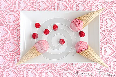 Scoops of Raspberry Ice Cream in Cones on Plate Stock Photo