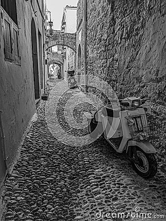 Greek Rhodes old town motorbike scooter alleyway. Black and white. Stock Photo