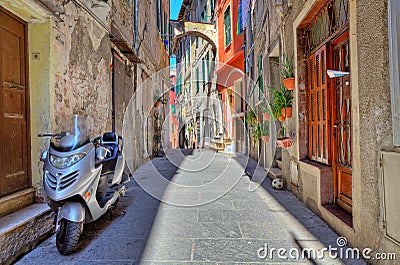 Scooter on narrow street in Ventimiglia, Italy. Stock Photo