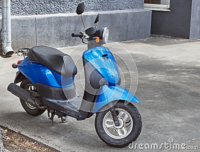 Scooter transport blue black color. Scooter motorcycle standing on the street. Stock Photo