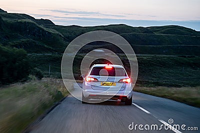 White Opel Vauxhall Astra Combi Ecotec car on a British roads during the early evening with lights on and motion blur speed effect Editorial Stock Photo