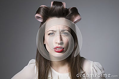 Scowling Young Female With Hair Rollers And Red Lipstick Stock Photo