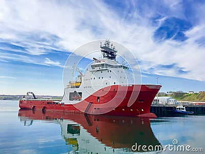 Offshore vessel AHTS Siem Opal moored inside harbour of Scrabster with blue skye and white clouds in the background Editorial Stock Photo