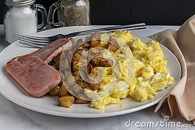 scramble eggs with homefries served with spam Stock Photo
