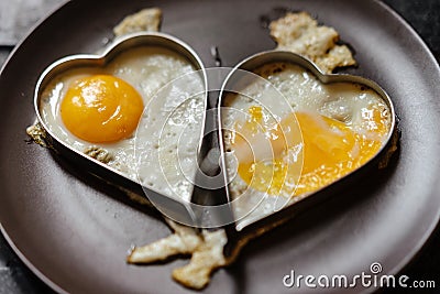 Scrambled couple eggs in hearts. Love theme. Stock Photo