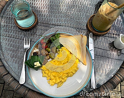 Scrambled egg breakfast with grilled vegetables, toast, and iced Stock Photo