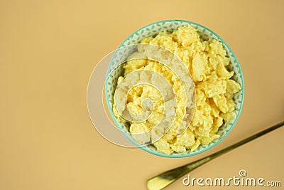 Scrambled eggs in bowl. Yolk and white are stirred and beaten together Stock Photo