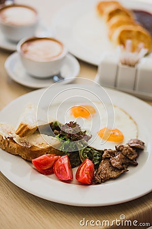 Scrambled eggs with french toasts and tomatoes Stock Photo