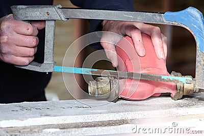 Scrap dealer seperating brass from an iron body Stock Photo