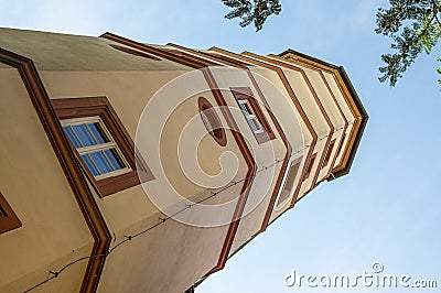 Scrap tower in the city of Schweinfurt with dynamic perspective, photographed in sunshine and blue skies framed by branches and Stock Photo