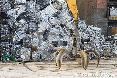 Scrap yard with grab and crushed cars Stock Photo