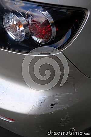 Scratched back bumper on the grey metallic car. Closeup image of damaged back bumper on the car. Photo for the insurance Stock Photo