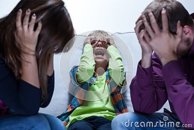 Screaming boy and tired parents Stock Photo