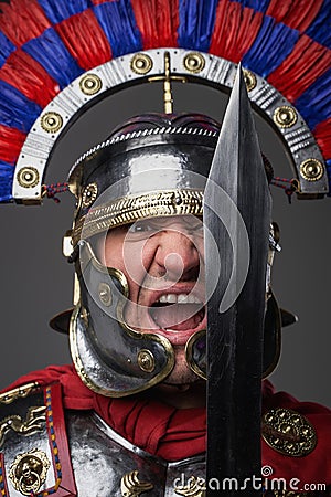 Screaming legionary with short sword against gray background Stock Photo