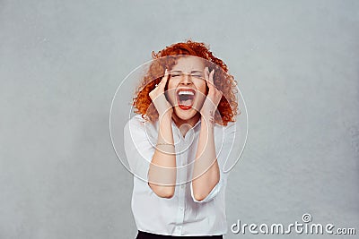 Screaming stressed. Portrait frustrated shocked redhead business woman yelling eyes closed hands on head temper tantrum isolated Stock Photo