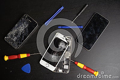 Screen cracked smartphone. Mobile phone with damaged touchscreen. Replacing broken screen. Stock Photo