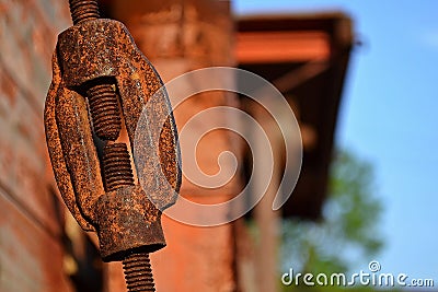 A thread - rusty, aged and dirty metallic part with a building in the background. Stock Photo