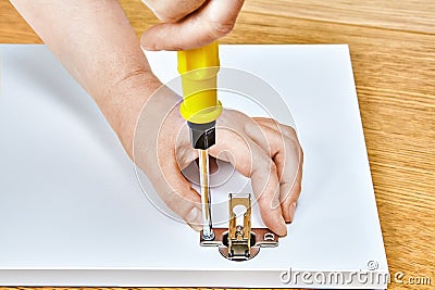tightening in furniture door hinges by assembly worker Stock Photo