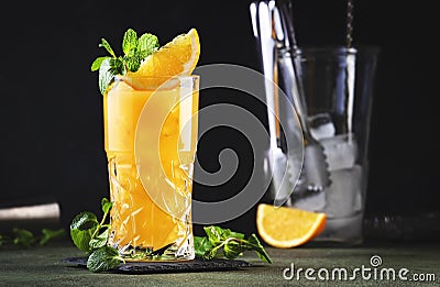 Screwdriver, classic alcoholic cocktail with vodka, orange juice and ice, garnished with fruit slice and mint. Dark background, Stock Photo
