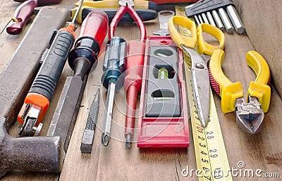 Screwdriver, hammer, tape measure placed on the wooden floor. Stock Photo
