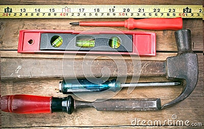 Screwdriver, hammer, tape measure placed on the wooden floor. Stock Photo