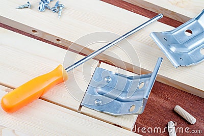 Screwdriver and self-tapping screws with metal corner elements for assembling the table Stock Photo