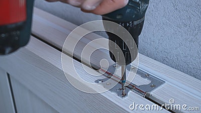 screwing the self-tapping screw into the door frame structure Stock Photo