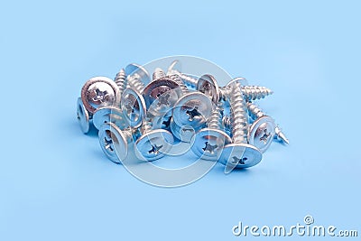 Screws a lot, macro photo. Long Iron or metal screw nails on blue backgraund. Front view Stock Photo