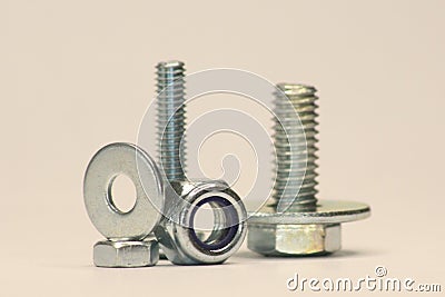 Screws with Washers and Nuts standing and lying on the Ground Stock Photo