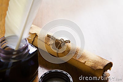 Scroll and quill pen on wooden table Stock Photo