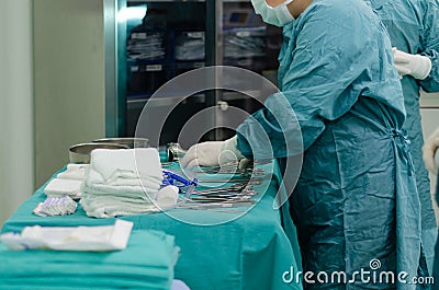 Scrub nurse is preparing medical instruments for operation Stock Photo