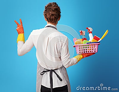 Scrubwoman with a basket with detergents showing victory Stock Photo