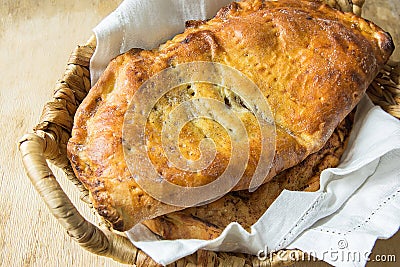 Scrumptious Home Baked Italian Pastry Calzone with Sweet Apple Pie Raisins Cinnamon Filling in Wicker Basket on White Linen Napkin Stock Photo