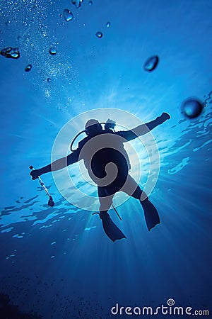 Scuba diver in the blue water descending in to the depth Stock Photo