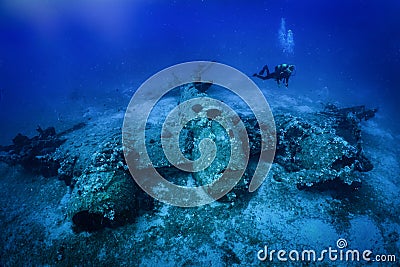 A scuba diver explores a sunken world war two fighter propeller airplane Stock Photo