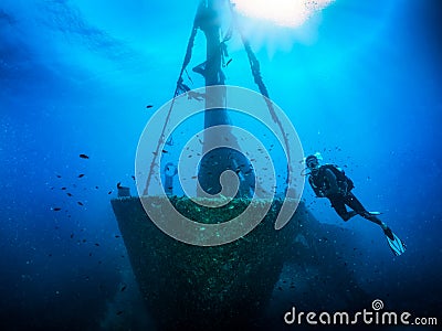 A scuba diver in front of a sunken shipwreck Stock Photo