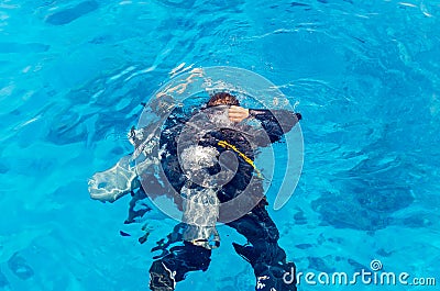 Scuba divers dive into the clear blue water in the sea Stock Photo