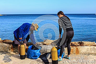 Scuba divers prepare their equipment before diving. Editorial Stock Photo