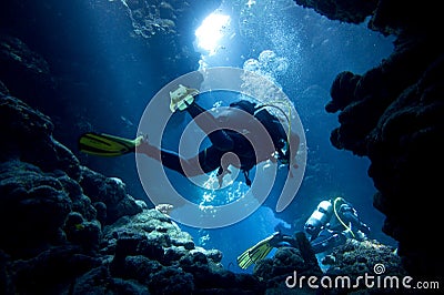 Scuba divers in underwater cave Stock Photo