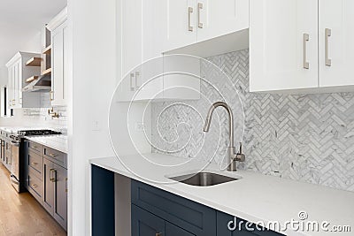 A scullery or butler's pantry detail with a bronze faucet and herringbone tile backsplash. Stock Photo