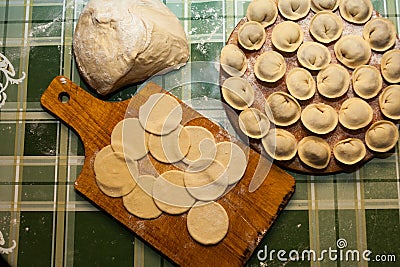 Sculpt pierogy and pelmeni concept. Include rustic cutting board, making pierogies on a rustic wooden table. dumplings Stock Photo