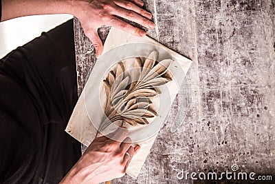 The sculptor creates a bas-relief. Plaster workshop. Close up. Selective focus Stock Photo