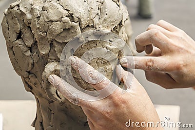 sculptor creates a bust and puts his hands clay on the skeleton of the sculpture Stock Photo