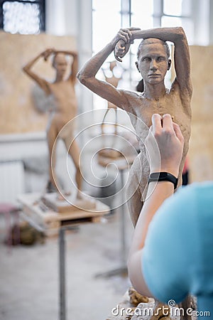 The sculptor sculpts a man`s sculpture from nature. Vertical frame Stock Photo