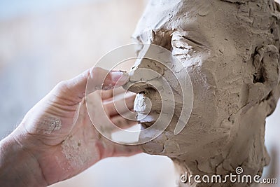 A sculptor sculpts a sculpture of a person`s face. Horizontal frame Stock Photo