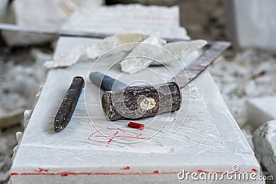 Sculptor tools on a marble slab, close up. Workplace, traditional tools sculptor, red chalk, ruler, hammer and chisel for working Stock Photo