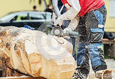 Sculptor work outddor with wooden blank and cutter Stock Photo