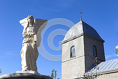Sculpture of an angel on the background of the Church of the Exaltation of the Holy Cross of the XVI century in Ternopil Ukraine. Stock Photo